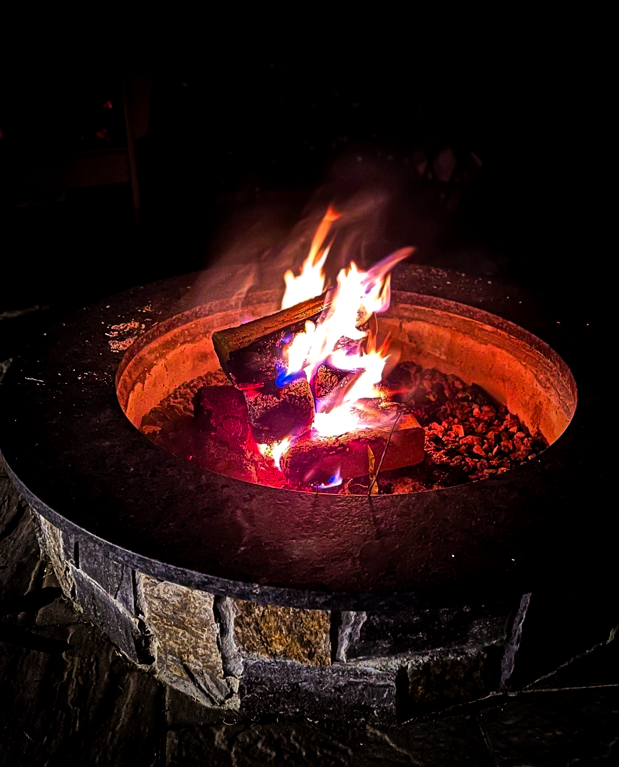 Fire pit with flames burning brightly against a dark background